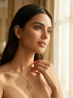 Woman wearing a 18k  gold plated necklace in a softly lit room