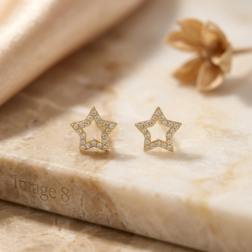 18k Gold plated star-shaped earrings with diamond accents on a marble surface.
