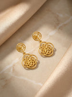 18k Gold plated earrings on a beige fabric background