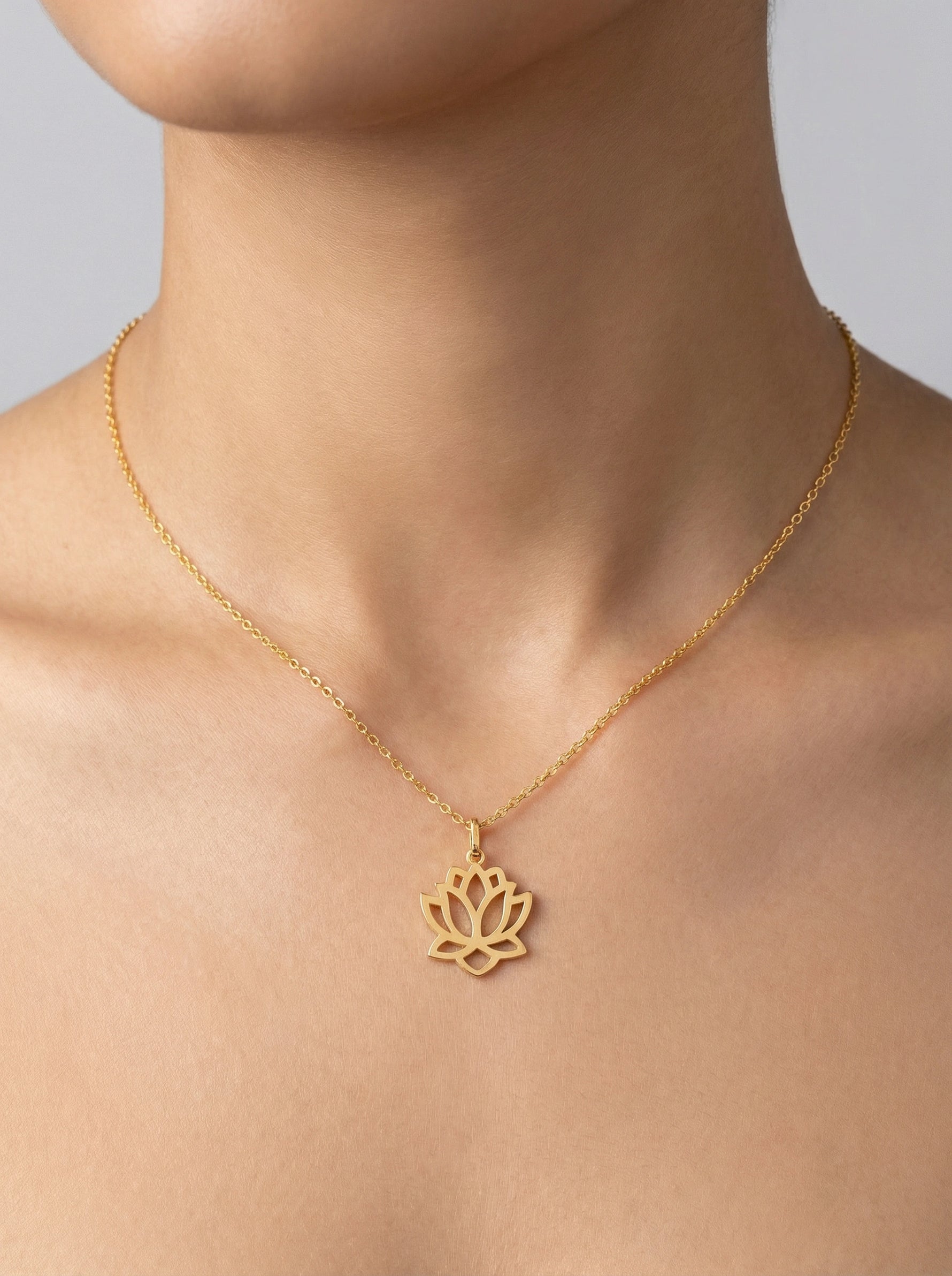 18k Gold plated necklace with a lotus flower pendant on a person's neck against a neutral background