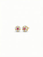 Pair of 18k gold plated earrings with ruby stones on a white background