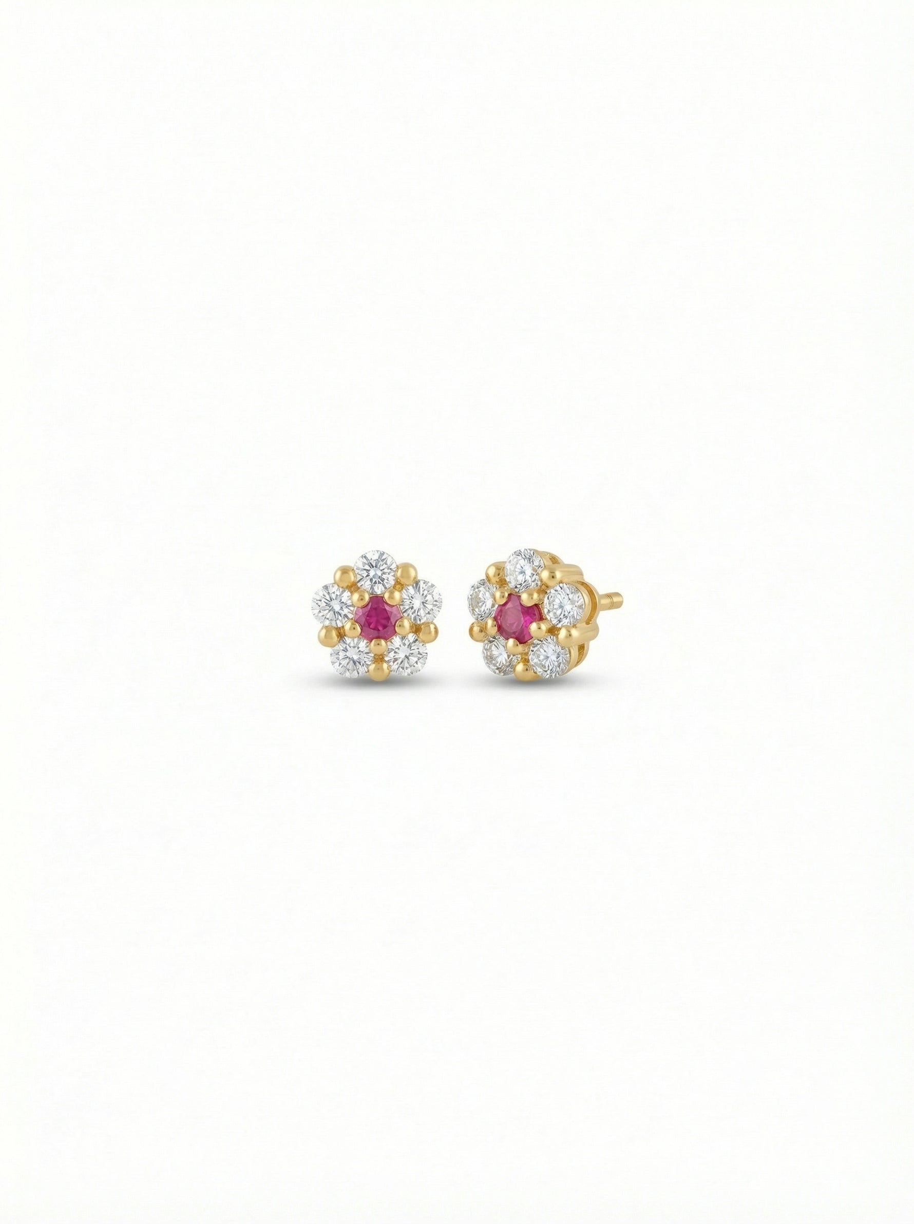 Pair of 18k gold plated earrings with ruby stones on a white background