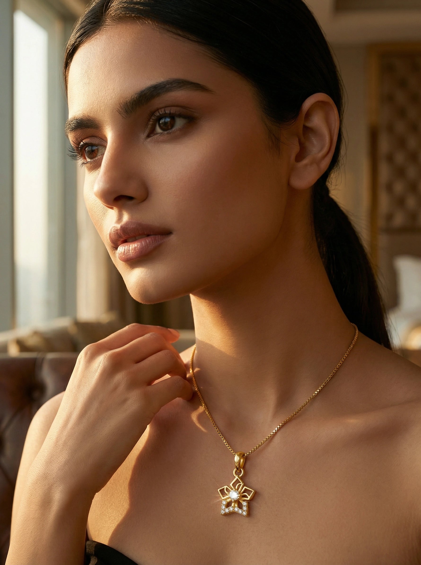 Woman wearing a 18k gold plated necklace with a pendant indoors