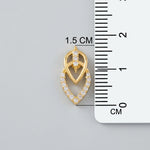 18k Gold plated heart-shaped pendant with embedded stones next to a ruler for size measurement on a gray background