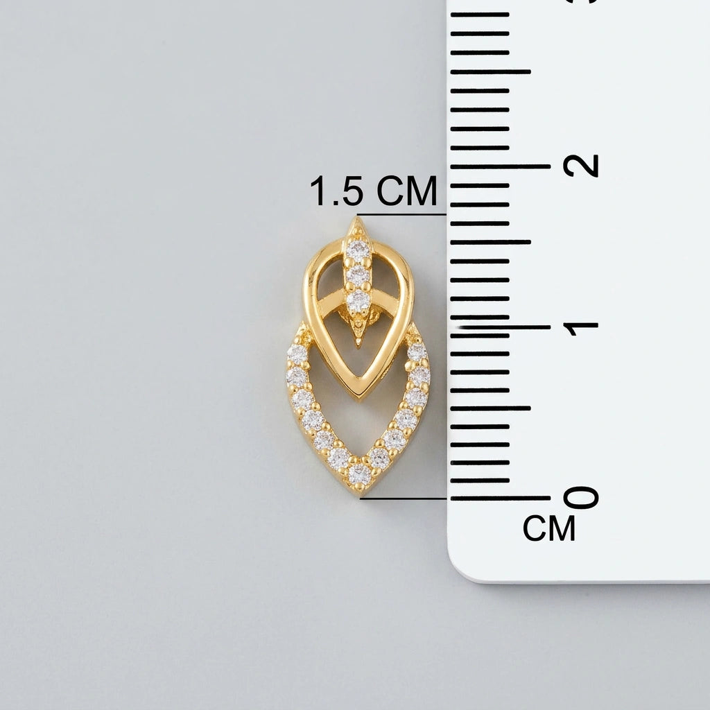18k Gold plated heart-shaped pendant with embedded stones next to a ruler for size measurement on a gray background