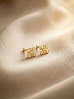 18k Gold plated earrings with gemstones on a beige fabric background