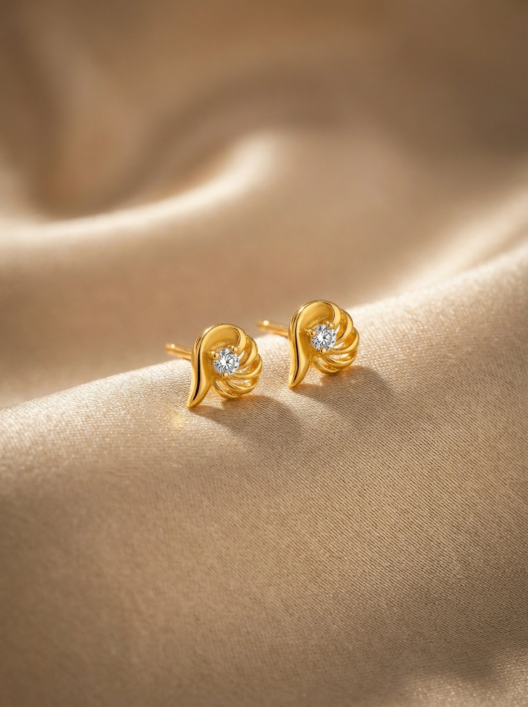 18k Gold plated earrings with diamond accents on a beige fabric background